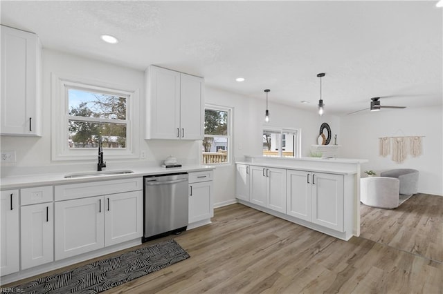 kitchen with white cabinetry, sink, kitchen peninsula, and dishwasher