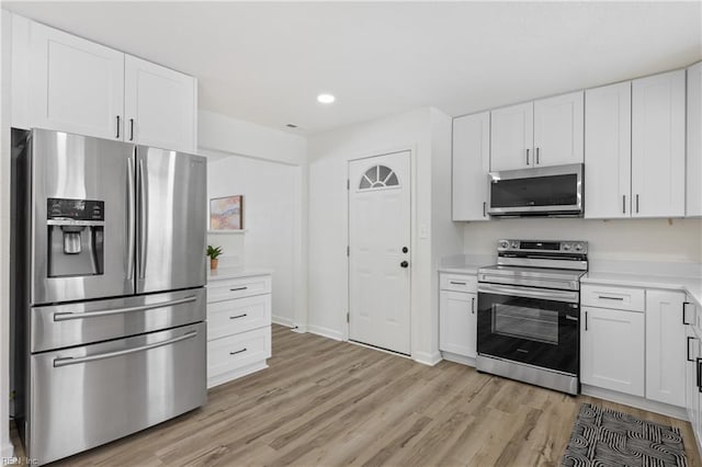 kitchen featuring stainless steel appliances, light hardwood / wood-style floors, and white cabinets