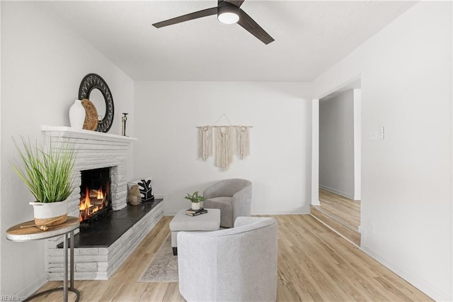 sitting room with ceiling fan and light wood-type flooring