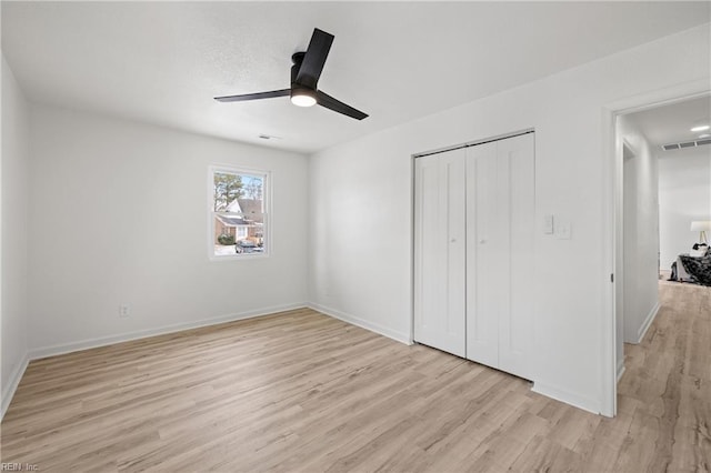 unfurnished bedroom with ceiling fan, light hardwood / wood-style floors, and a closet