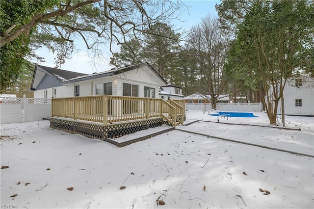 snow covered property with a deck