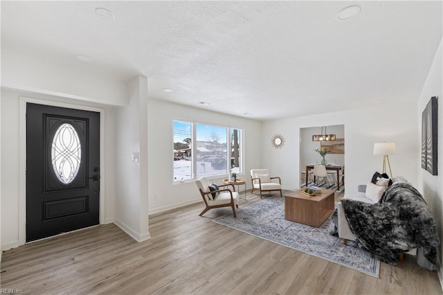 foyer entrance featuring a textured ceiling and light hardwood / wood-style flooring