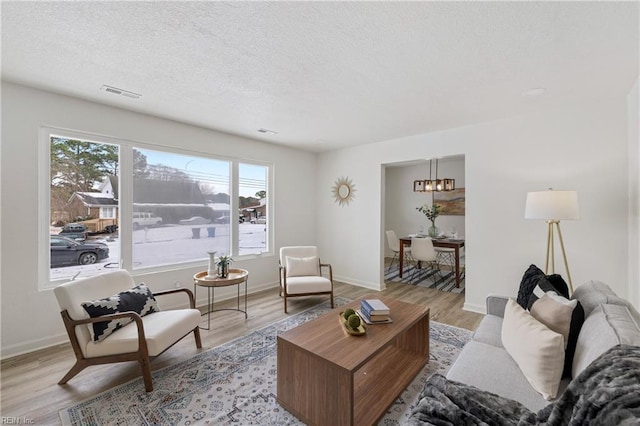 living room featuring a textured ceiling and light wood-type flooring