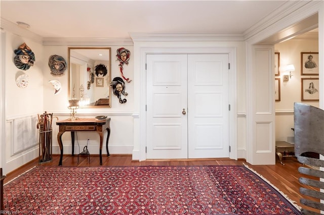 foyer entrance with wood-type flooring and ornamental molding