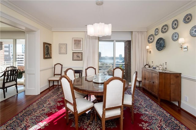 dining room featuring a notable chandelier, a wealth of natural light, dark wood-type flooring, and ornamental molding