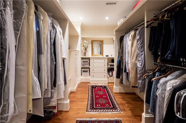 walk in closet with light hardwood / wood-style flooring