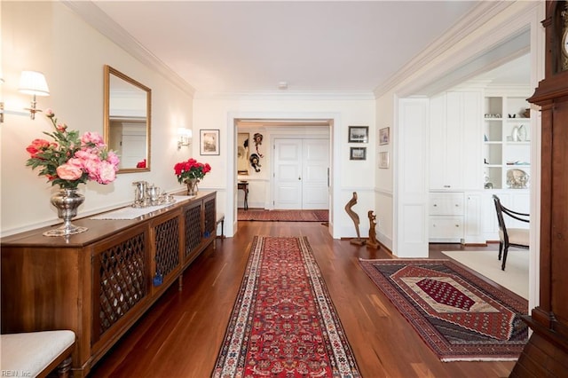 hall featuring built in shelves, ornamental molding, and dark hardwood / wood-style floors