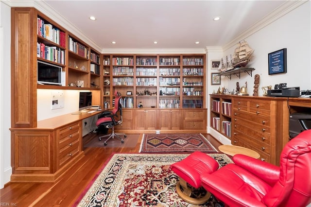 office area with hardwood / wood-style floors, crown molding, and built in desk