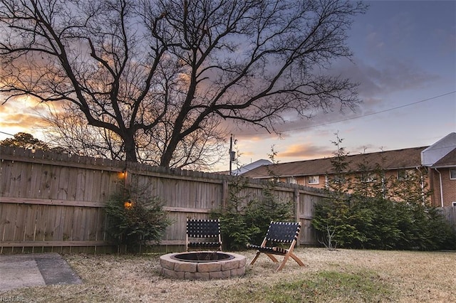 yard at dusk featuring a fire pit