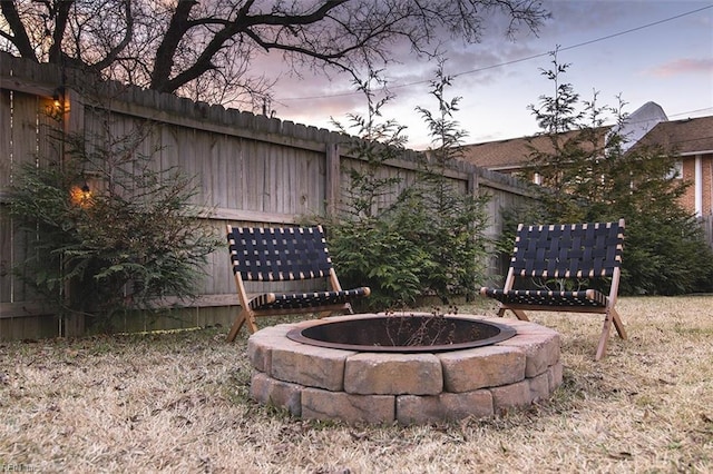 yard at dusk featuring a fire pit