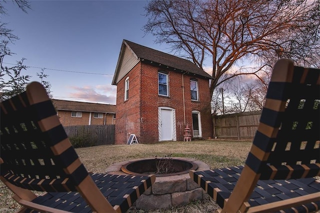 back house at dusk featuring a fire pit