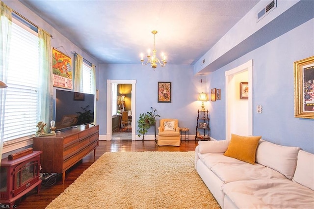 living room with an inviting chandelier and dark wood-type flooring