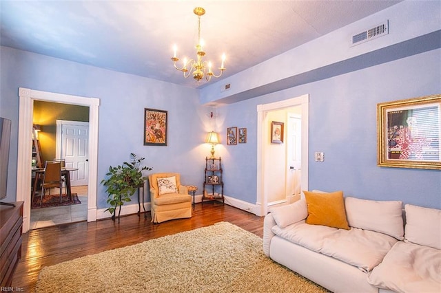 living room with dark wood-type flooring and a chandelier