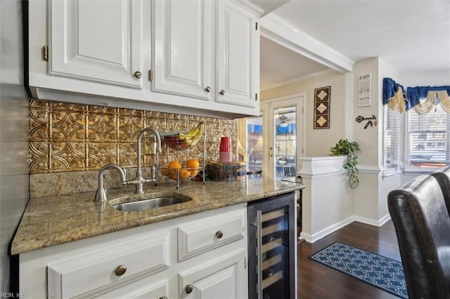 kitchen featuring light stone counters, tasteful backsplash, beverage cooler, and white cabinets