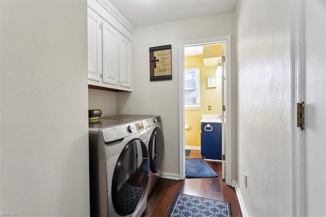 laundry room with dark hardwood / wood-style flooring, cabinets, and washing machine and clothes dryer