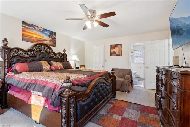 bedroom with dark carpet, ensuite bath, and ceiling fan