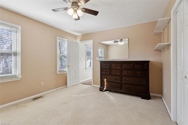 bedroom with light colored carpet, ceiling fan, and a closet