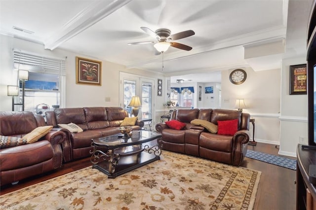 living room featuring ceiling fan, a wealth of natural light, dark wood-type flooring, and beamed ceiling