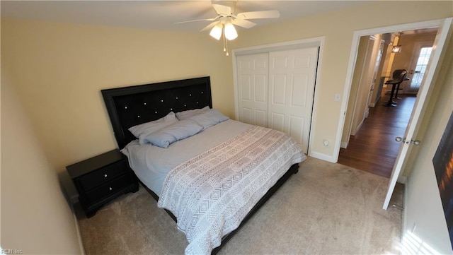 bedroom with light colored carpet, a closet, and ceiling fan