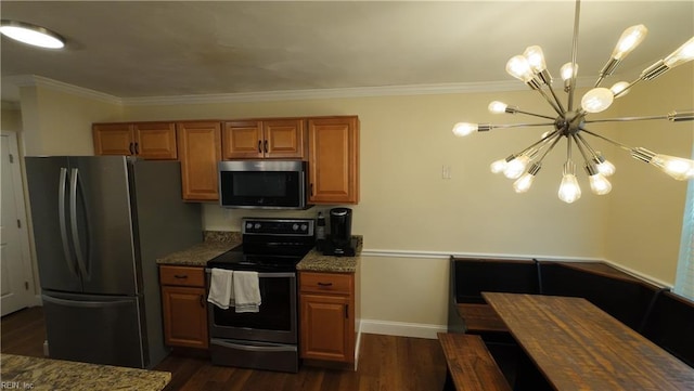 kitchen featuring appliances with stainless steel finishes, light stone counters, ornamental molding, dark hardwood / wood-style flooring, and a chandelier