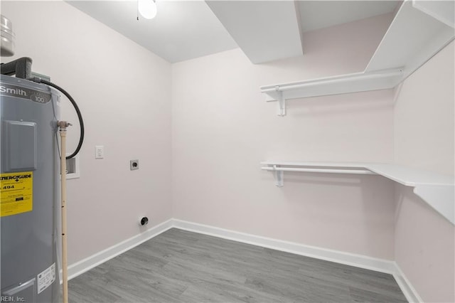 laundry room with wood-type flooring, electric water heater, and hookup for an electric dryer