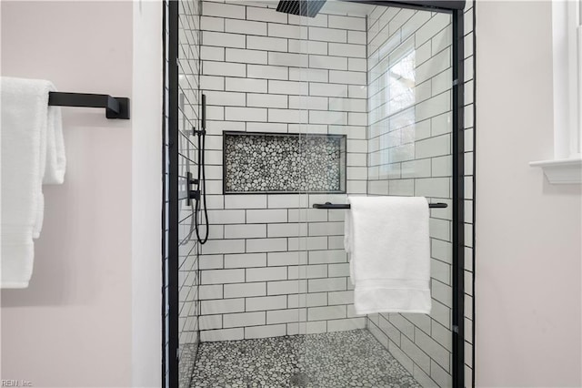 bathroom featuring a shower with door