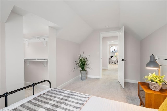 bedroom featuring lofted ceiling and light carpet