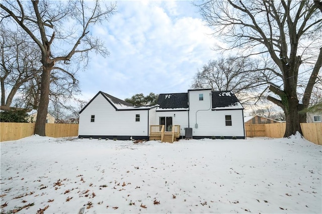 snow covered back of property with central air condition unit