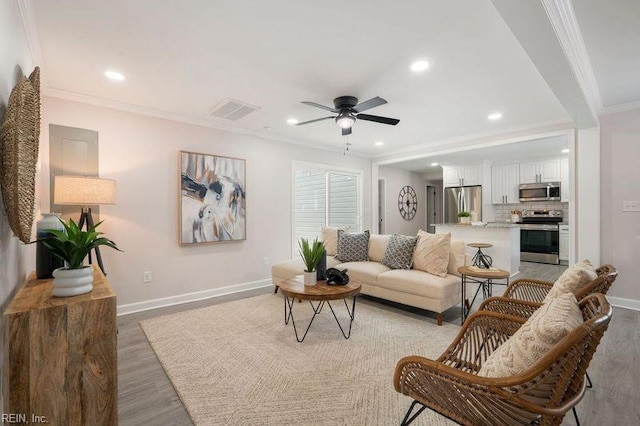 living room with crown molding, ceiling fan, and light wood-type flooring