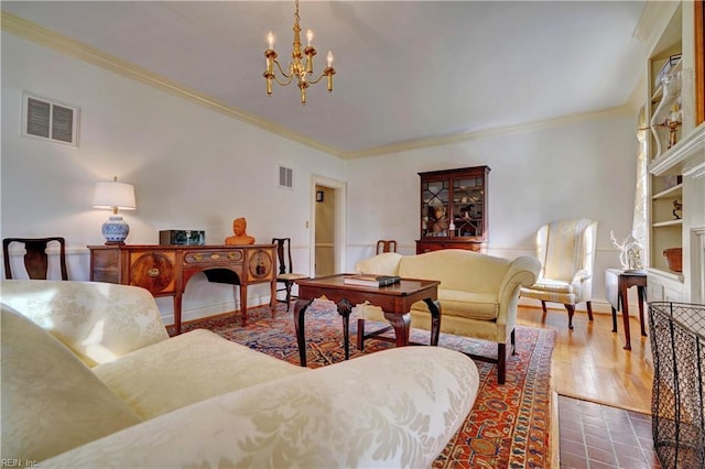 living room with ornamental molding, hardwood / wood-style floors, and a notable chandelier