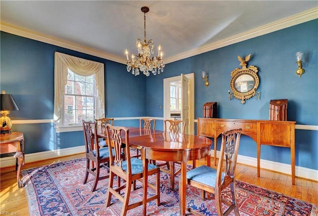 dining room featuring crown molding, light hardwood / wood-style floors, and a chandelier