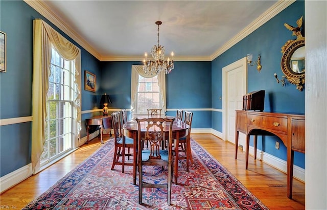 dining area with crown molding, hardwood / wood-style floors, and an inviting chandelier