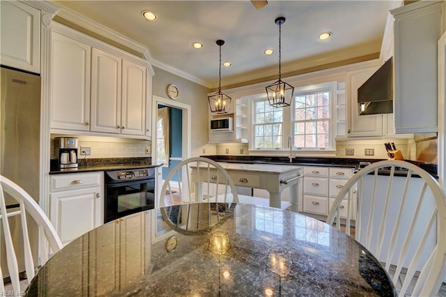 kitchen with white cabinetry, pendant lighting, black oven, and dark stone counters