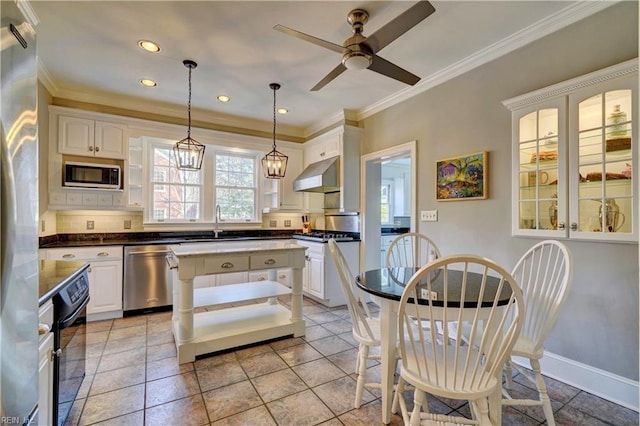 kitchen featuring built in microwave, wall chimney range hood, stainless steel dishwasher, and white cabinets