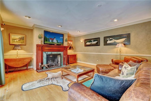 living room with a high end fireplace, ornamental molding, and hardwood / wood-style floors