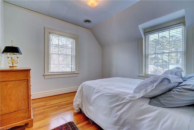 bedroom featuring lofted ceiling and light wood-type flooring