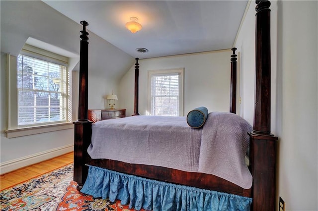 bedroom featuring hardwood / wood-style flooring and vaulted ceiling