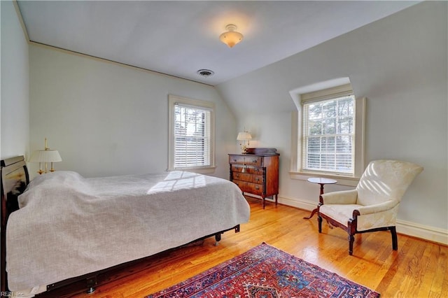 bedroom with lofted ceiling and light hardwood / wood-style floors