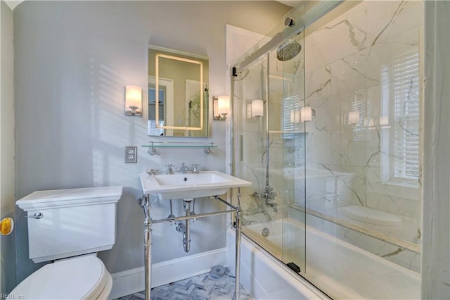 full bathroom with bath / shower combo with glass door, sink, and toilet