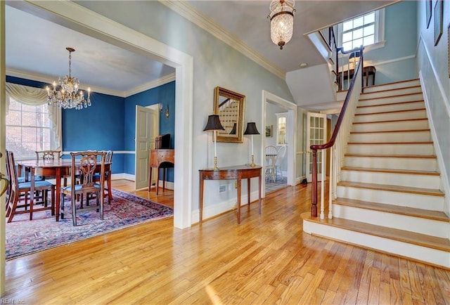 dining room with ornamental molding, a notable chandelier, and light wood-type flooring