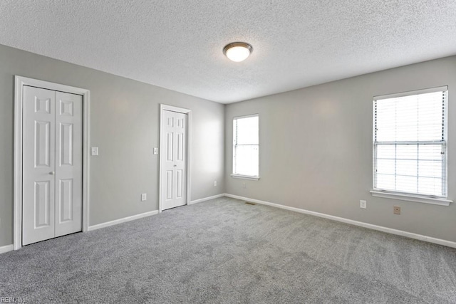 carpeted spare room featuring plenty of natural light and a textured ceiling