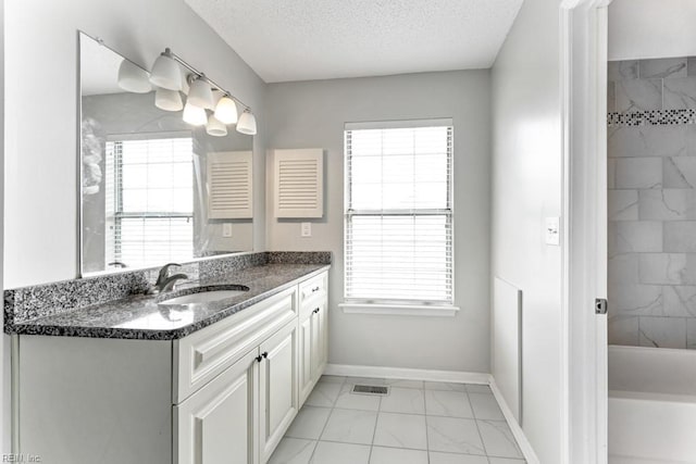 bathroom featuring vanity, plenty of natural light, and a textured ceiling