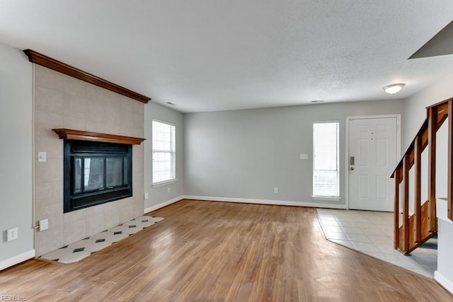 unfurnished living room featuring a textured ceiling, a fireplace, and light hardwood / wood-style flooring