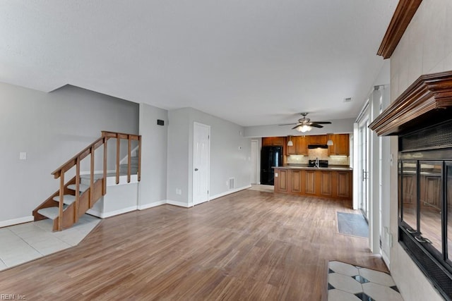 unfurnished living room with ceiling fan and light hardwood / wood-style flooring