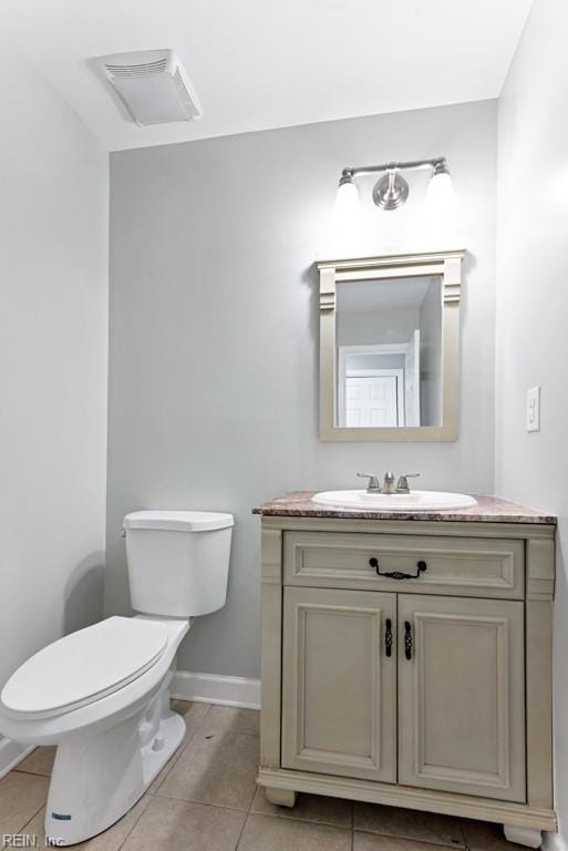 bathroom with tile patterned flooring, vanity, and toilet