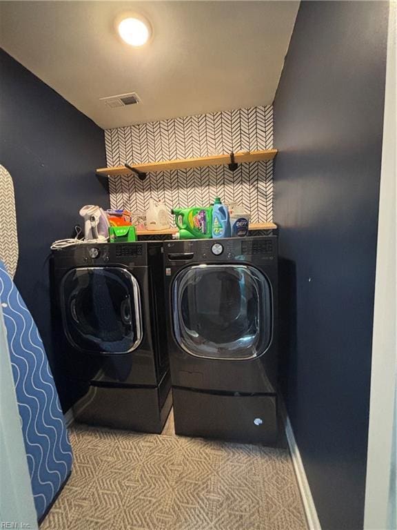 laundry area featuring light carpet and washer and clothes dryer