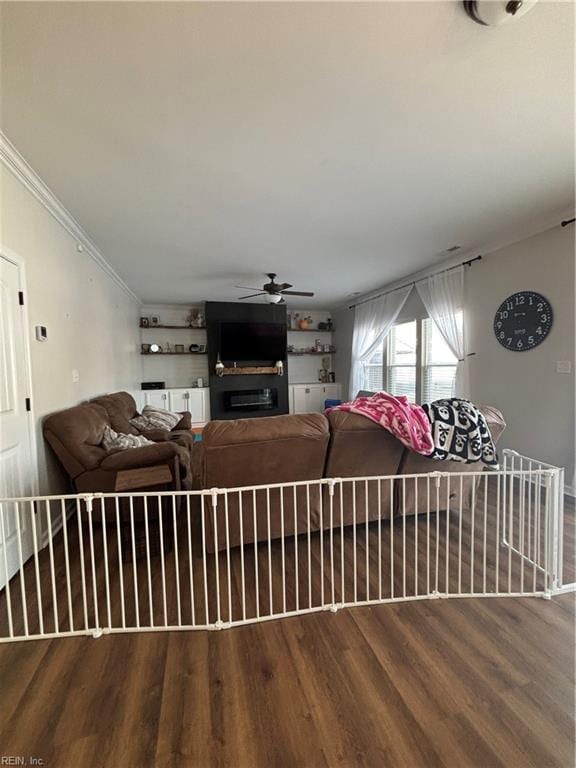 living room featuring crown molding, wood-type flooring, and ceiling fan