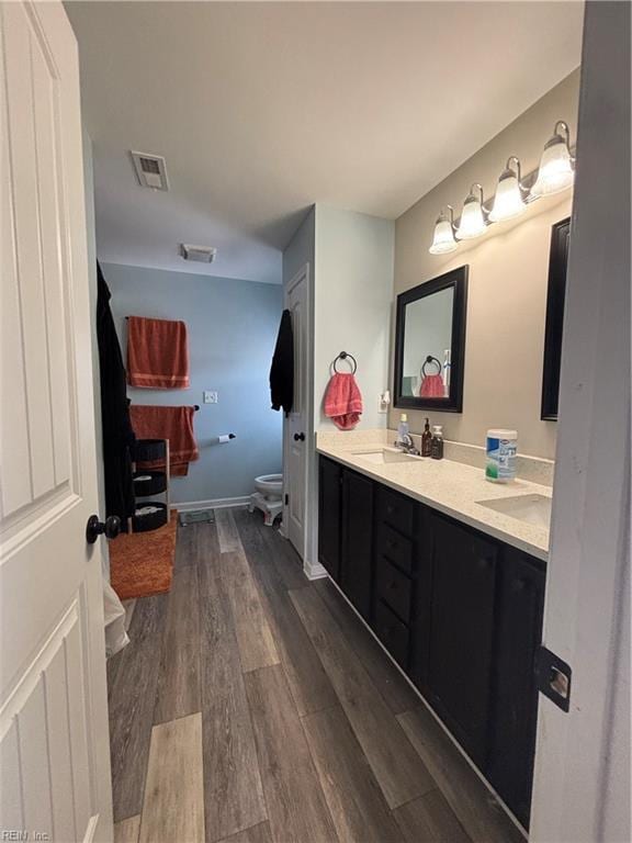 bathroom with hardwood / wood-style flooring, vanity, and toilet