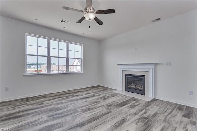 unfurnished living room featuring ceiling fan and light hardwood / wood-style floors