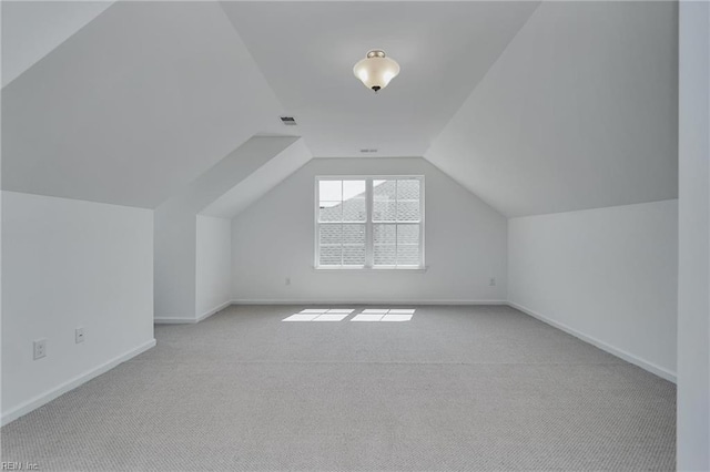 additional living space with light carpet and vaulted ceiling